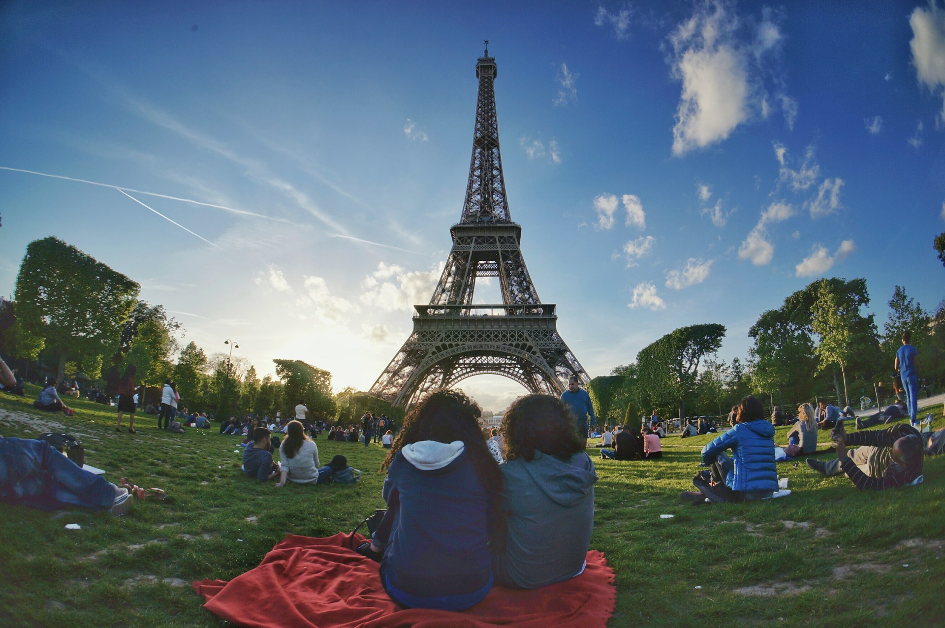 Ragazzi che si rilassano sul prato del Campo di Marte con la Torre Eiffel sullo sfondo