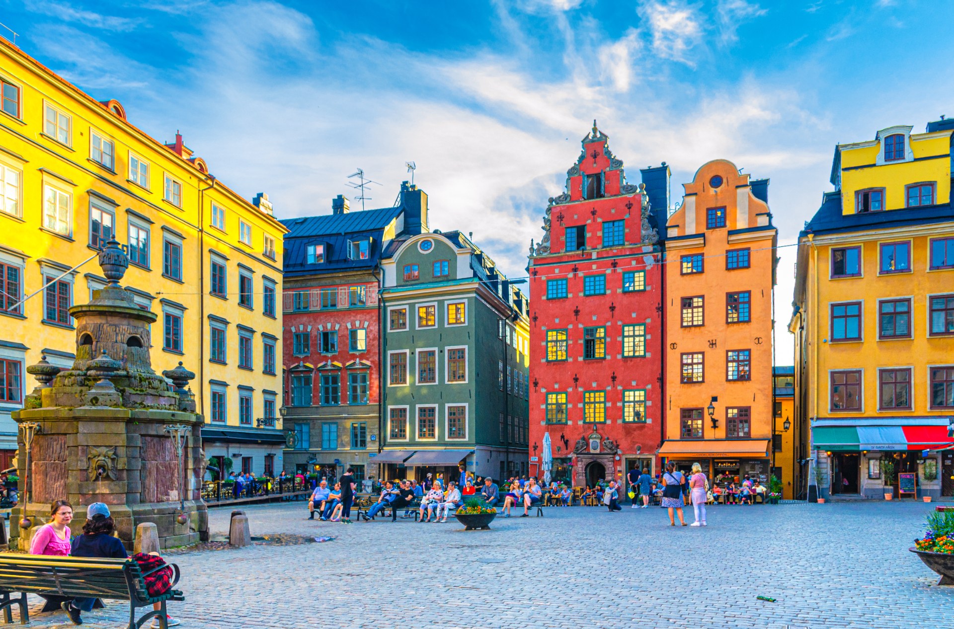 Turisti e passanti in piazza Stortorget a Stoccolma, tra case dai colori vivaci
