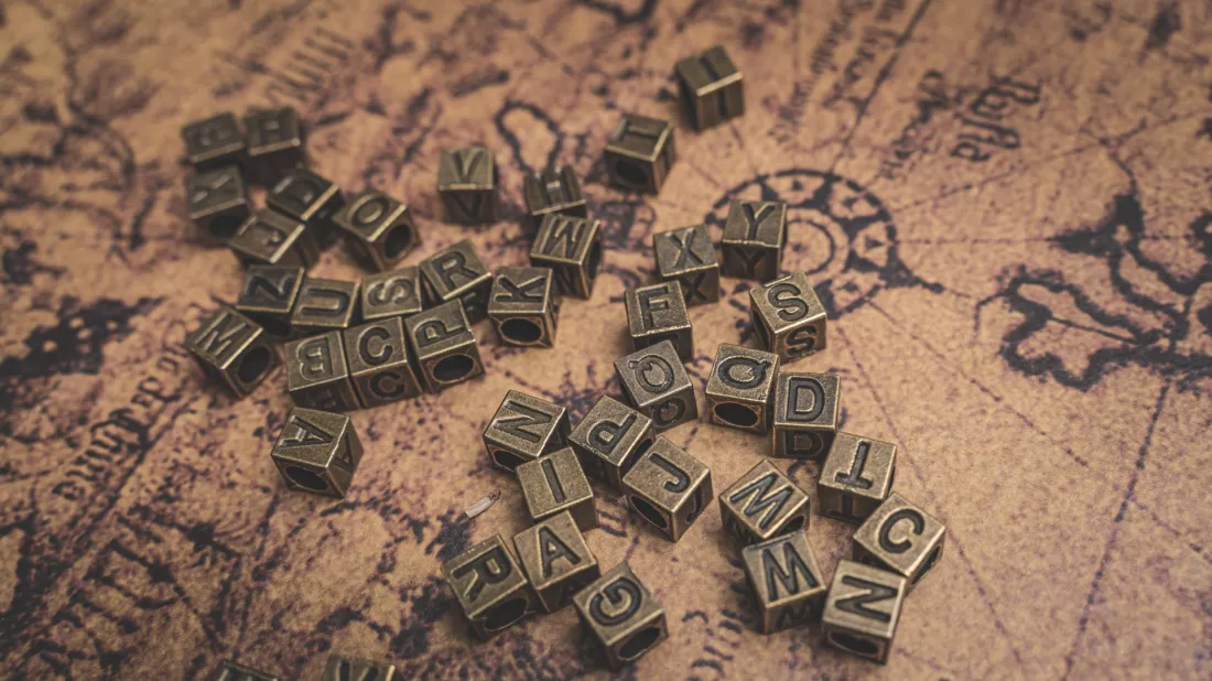 Lettere in bronzo su una vecchia mappa del mondo