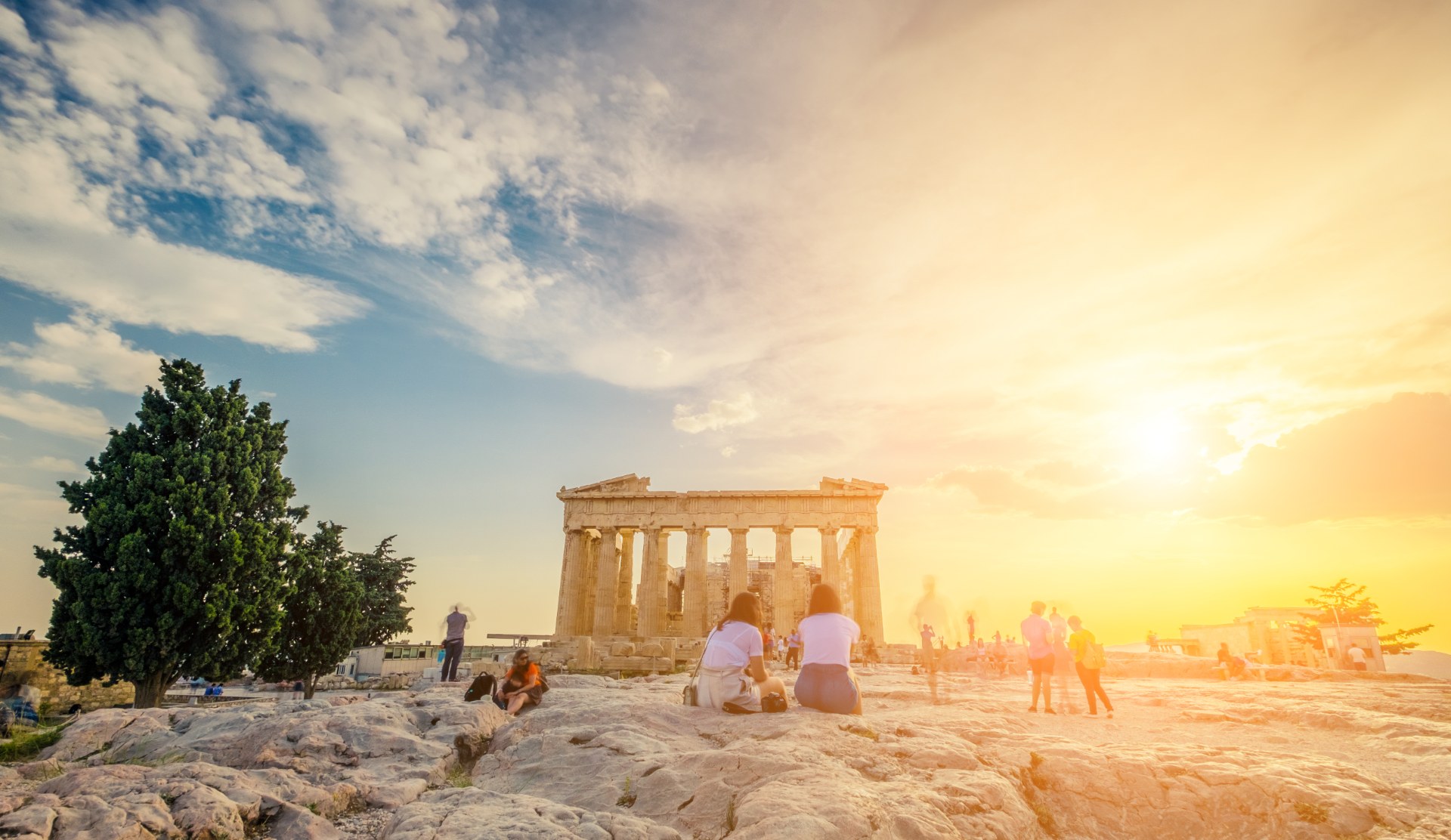 Ragazzi seduti davanti al Partenone sull’Acropoli al tramonto